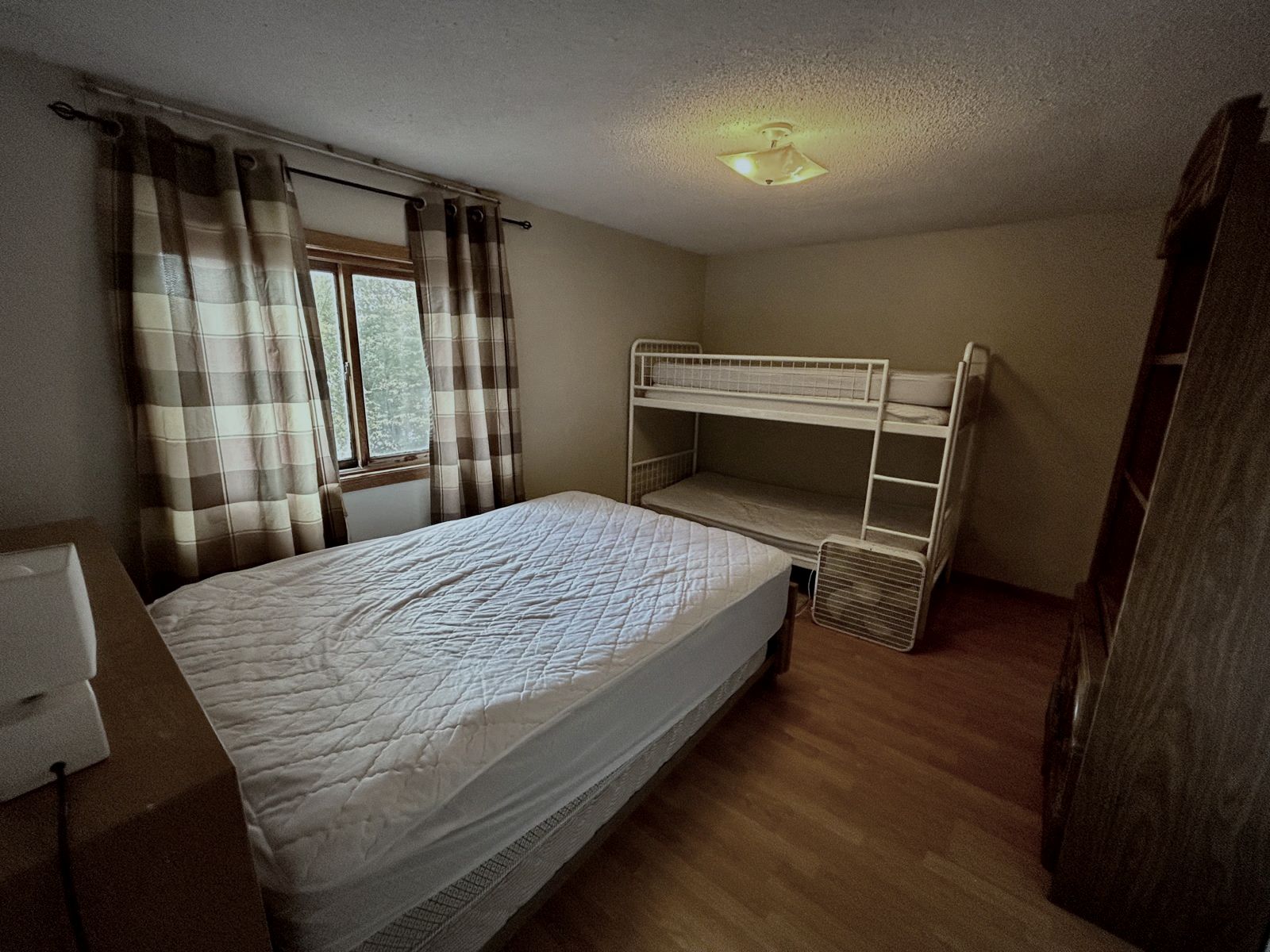 Small bedroom with a bunk bed and plaid curtains