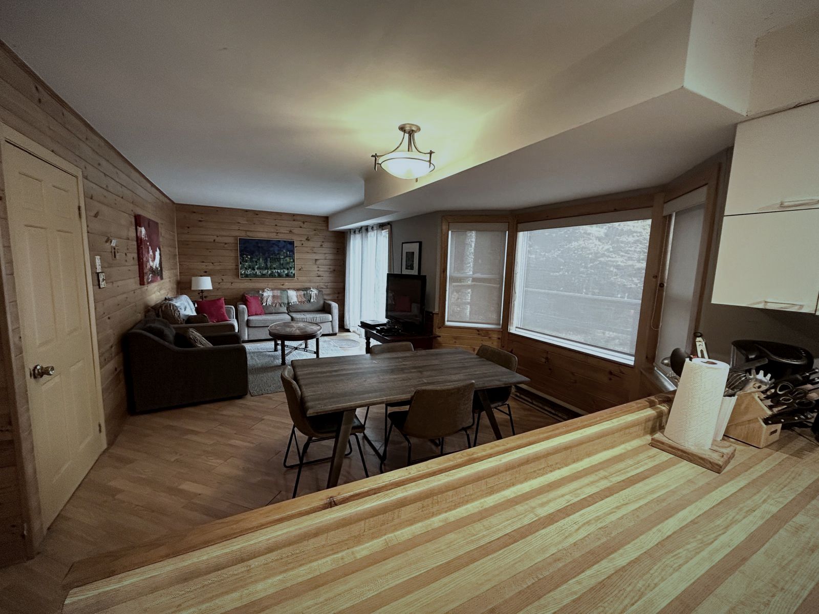 Dining table beside wide windows facing the lake